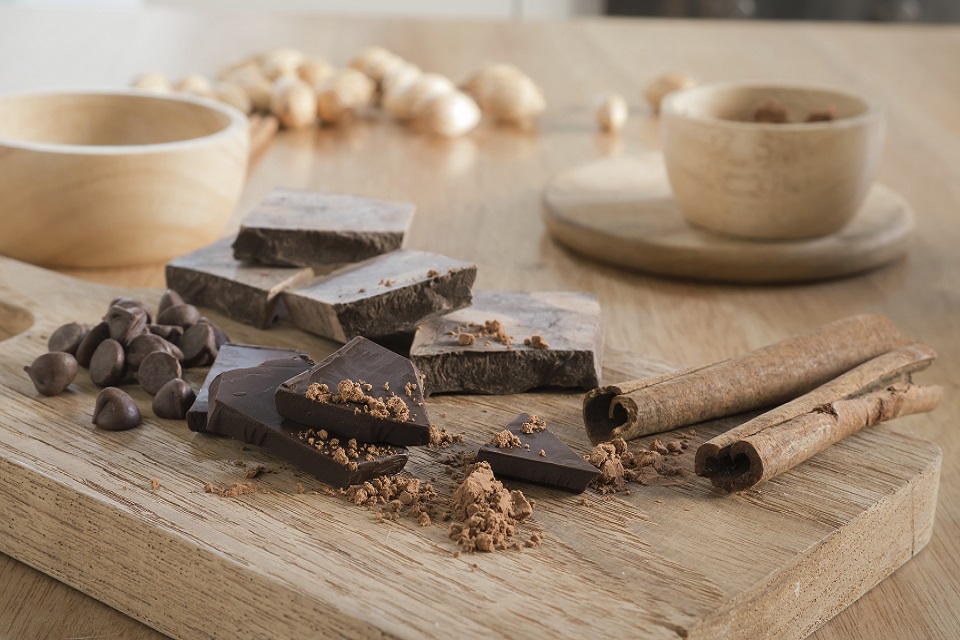 Dark chocolate with cocoa on wooden table