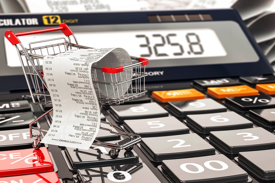 Shopping cart on calculator and receipt. Home budget or consumer