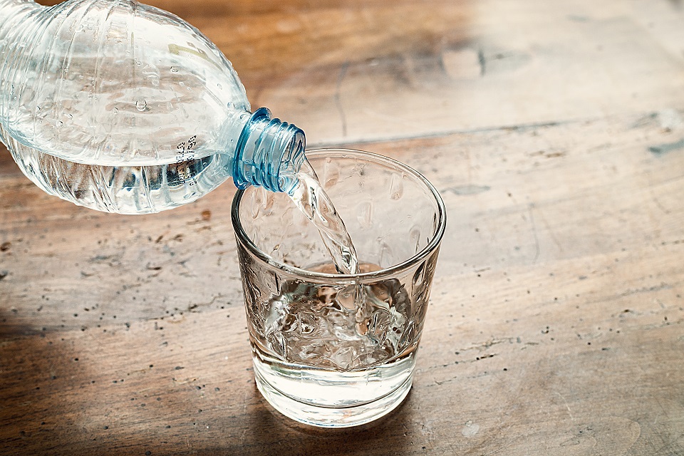 blue water bottle poured into a clear glass