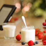 Person Reading e-book over Healthy Breakfast