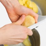 Woman cutting to peel potatoes. Kitchen working. Prepare food