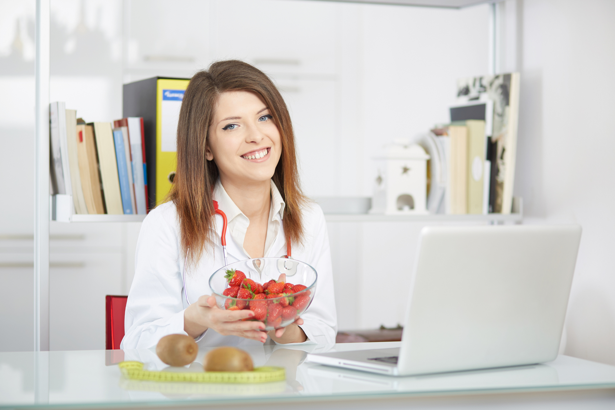 young nutritionist showing strawberries