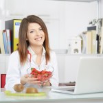 young nutritionist showing strawberries