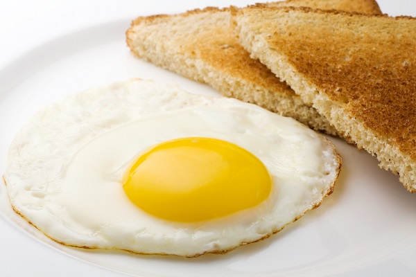 Fried egg sunny side up and plain sliced toast