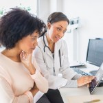 African American doctor and patient talking in office