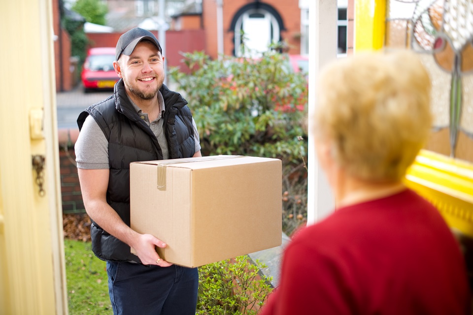 Friendly delivery man delivers parcel