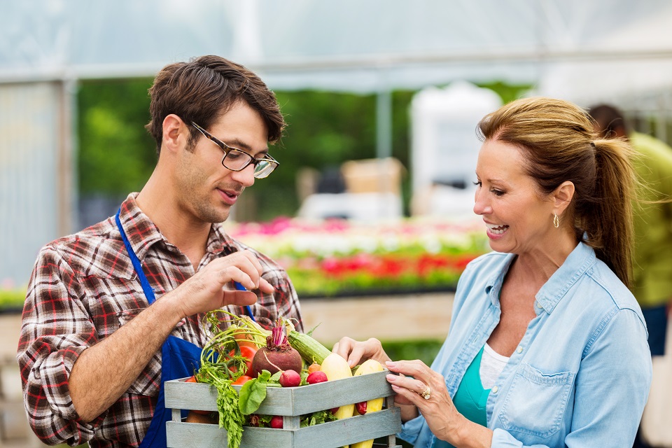 Young farmer talks about produce with customer