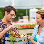 Young farmer talks about produce with customer
