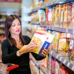 Woman checking food labeling in supermarket