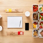 Healthy food take away in boxes, top view at wood