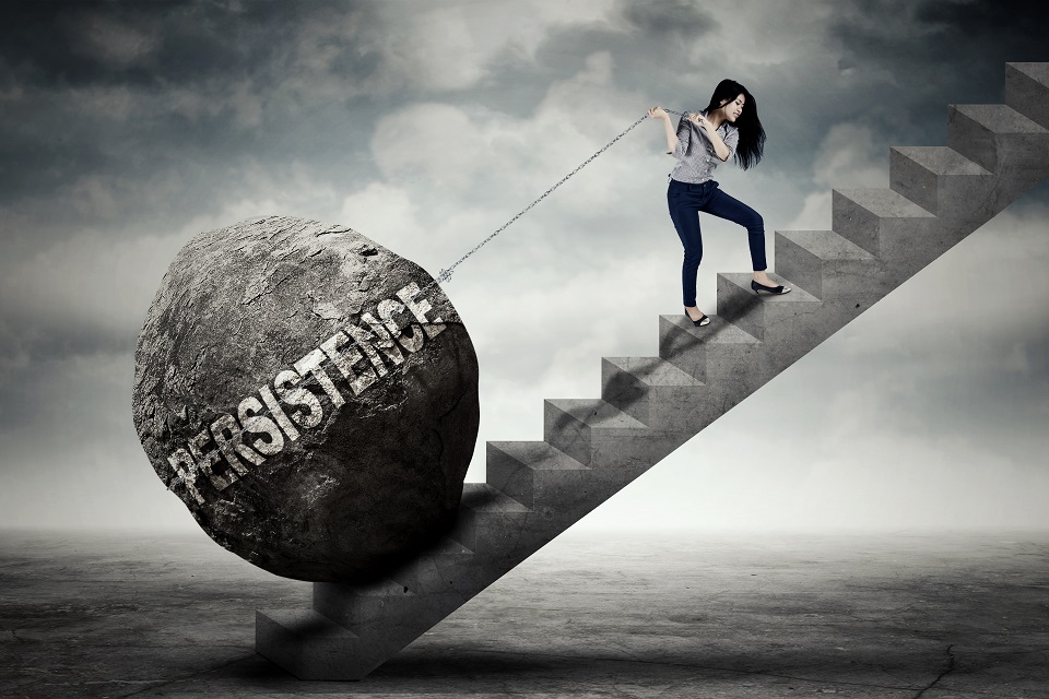 Female entrepreneur pulling persistence word on stair