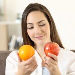 Girl deciding between two fruits