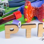 Medical laboratory abbreviation PTH or parathyroid hormone, which is secreted by  parathyroid gland and using his blood test may diagnose organ disease. Word PTH near model of thyroid, lab test tube