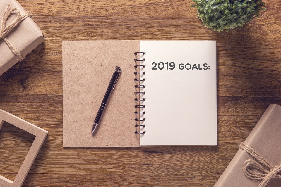 2019 goals list in notebook with gift box new year on wooden table background.
