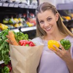 Smiling pretty blonde woman buying vegetables