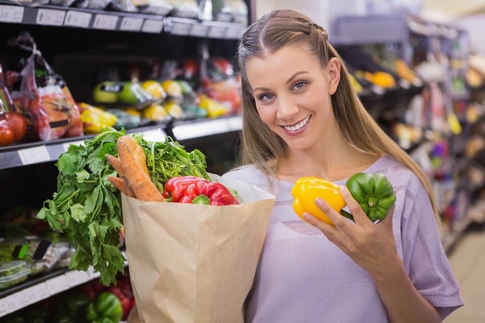 Smiling pretty blonde woman buying vegetables