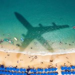 Airplane's shadow over a crowded beach