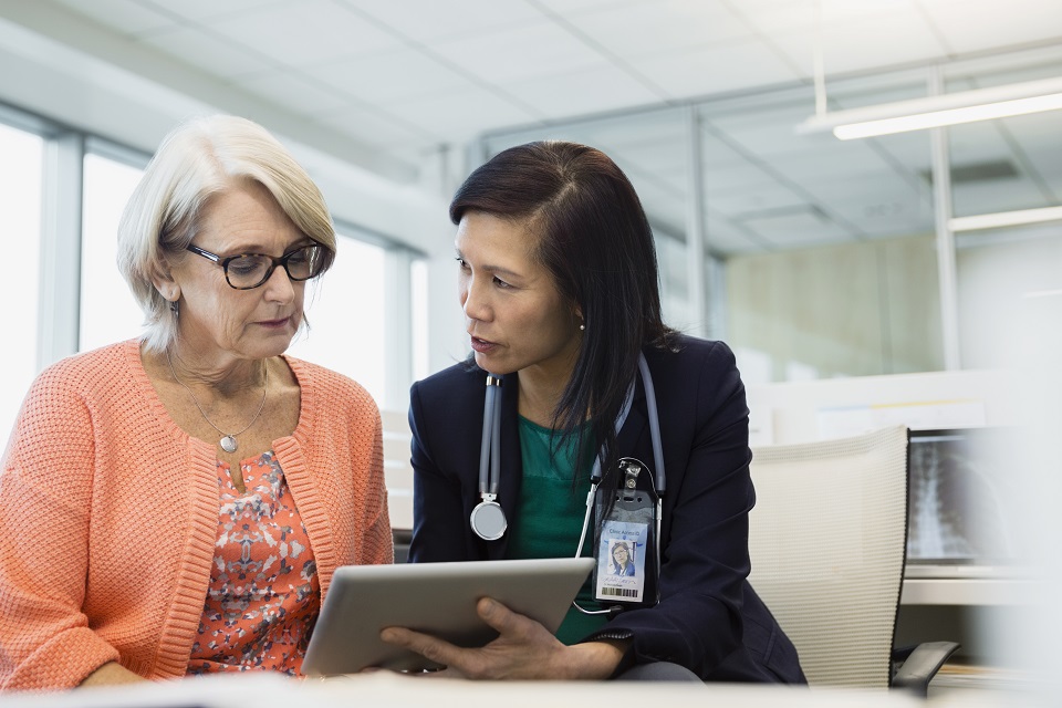 Female doctor showing lab results to older woman