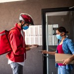 Pizza delivery person scanning bar code on customers smart phone and making a quick and easy contactless payment