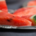 Still life closeup of triangular slices of watermelon in metal plate, selective focus.