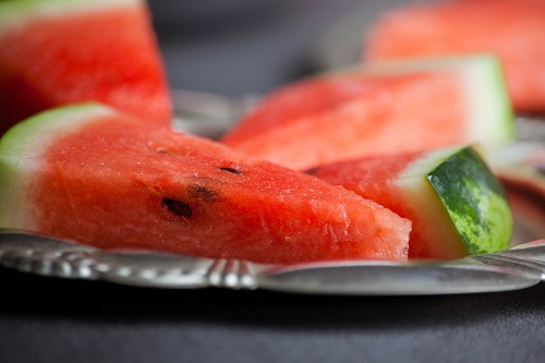 Still life closeup of triangular slices of watermelon in metal plate, selective focus.