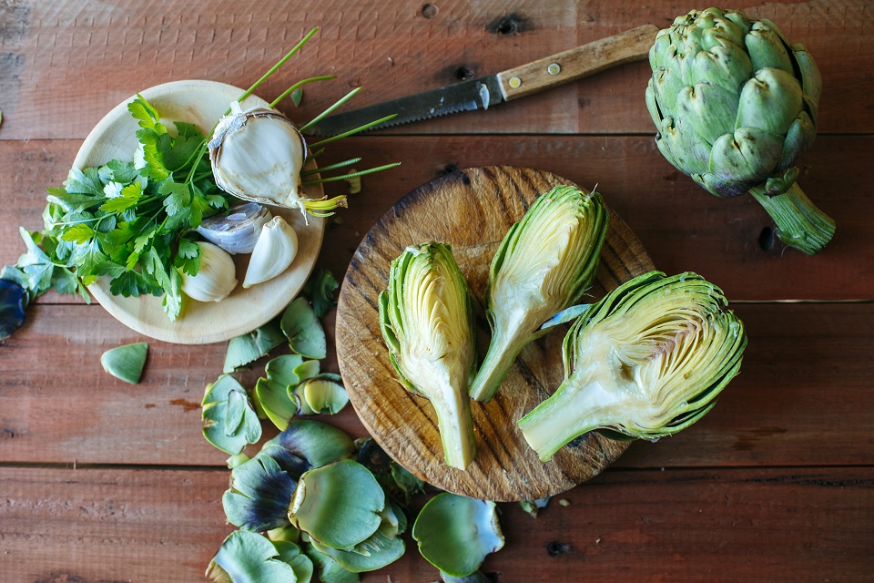 Sliced artichoke, parsley and garlic on wood