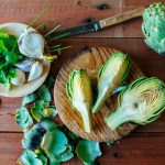 Sliced artichoke, parsley and garlic on wood