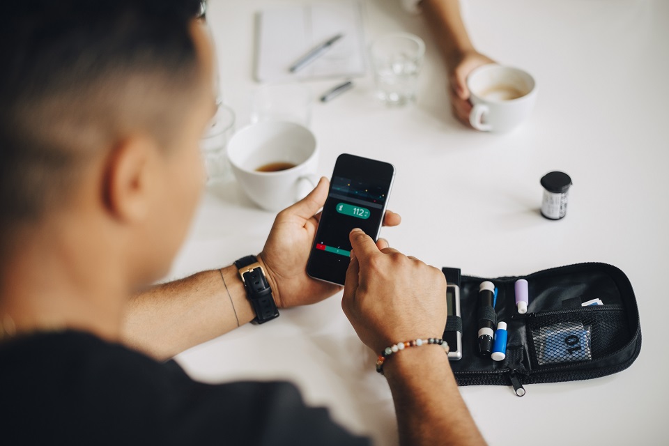 Person using blood glucose monitor to test glucose