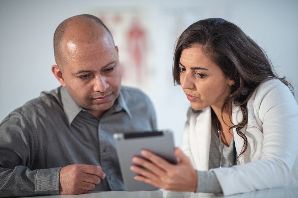 Female Dietitian Shares Information with Patient Using Digital Tablet