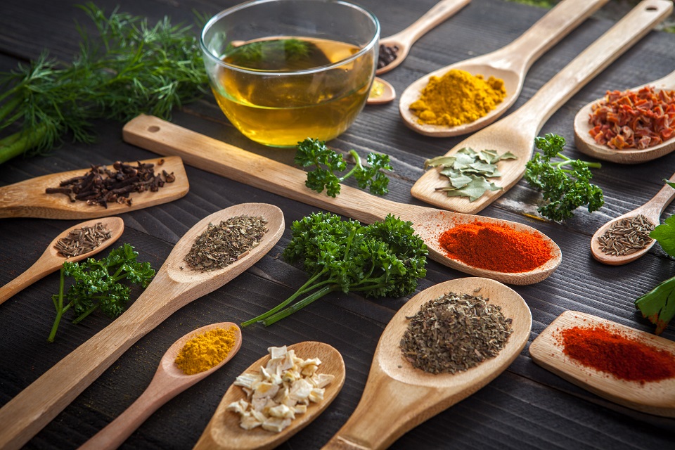 Various spice on wooden spoons with herbs
