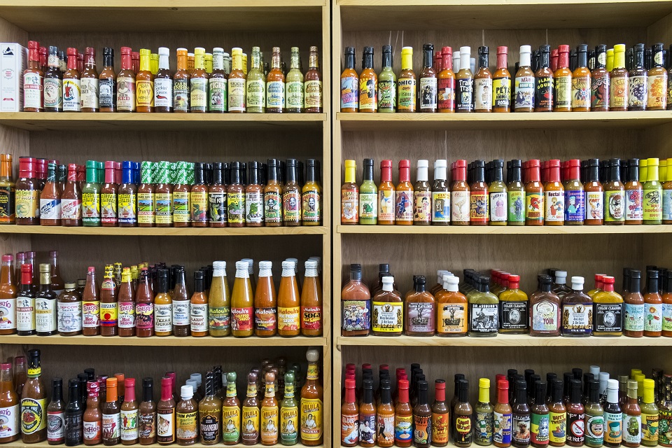 Jars of hot sauce on shelves in store