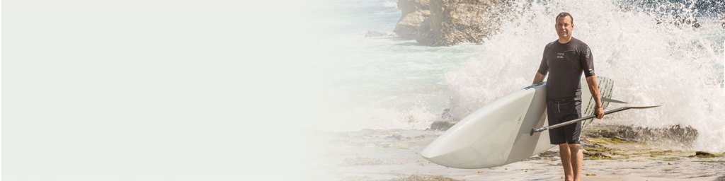 Man with a surfboard by the ocean