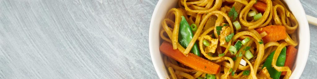Bowl of pasta with carrots and herbs