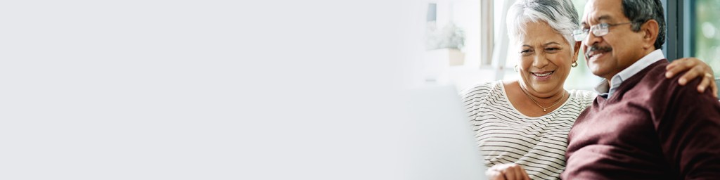 Older couple sitting with an arm around ones shoulder