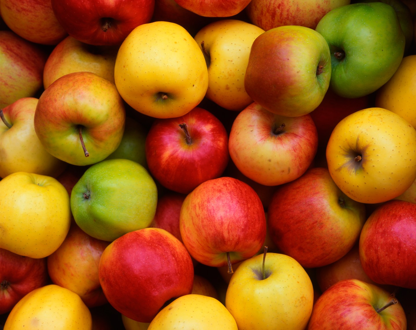 A close up of yellow, red, and green apples