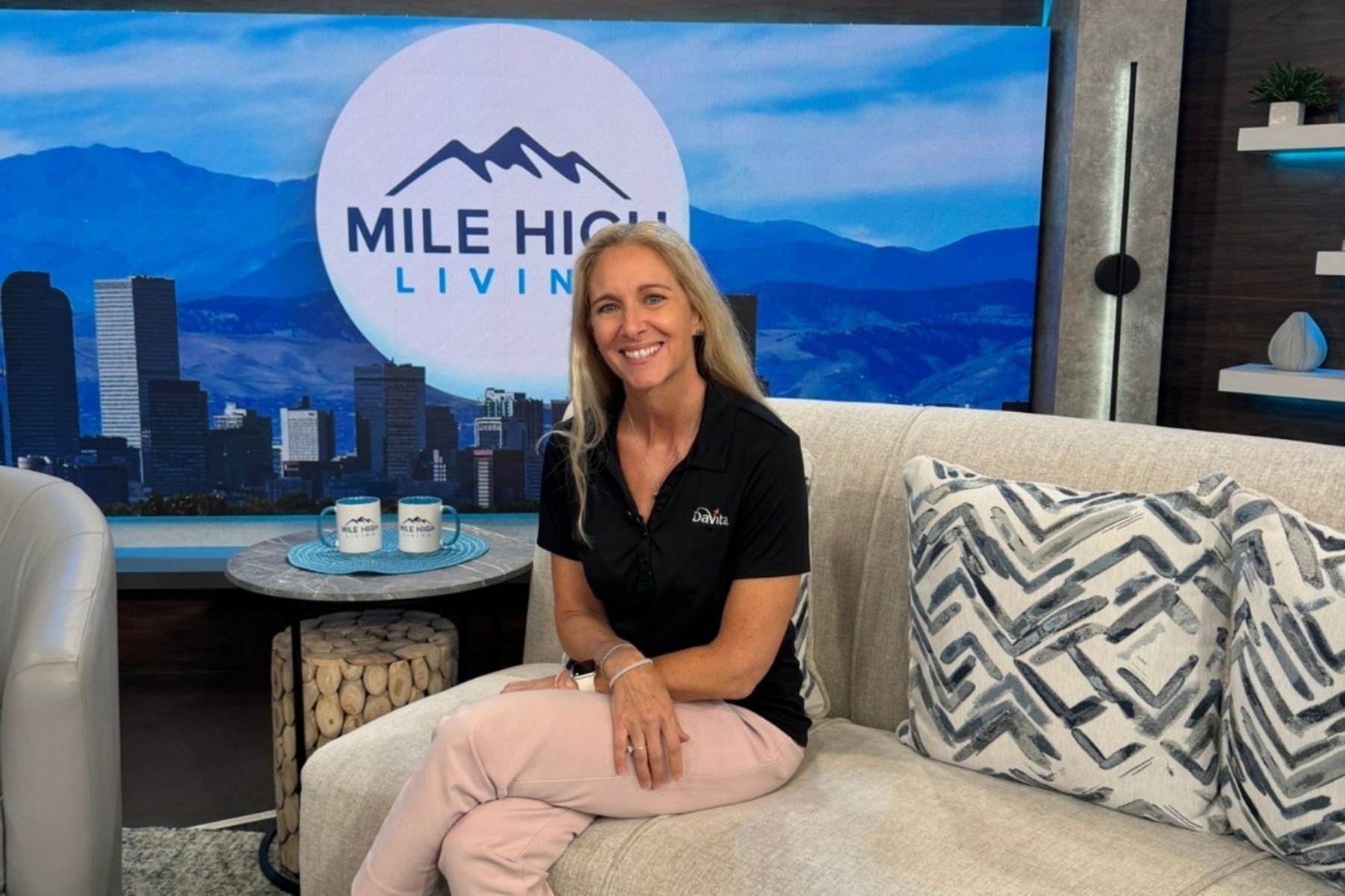 Angela Laino smiling on a couch at mile high living