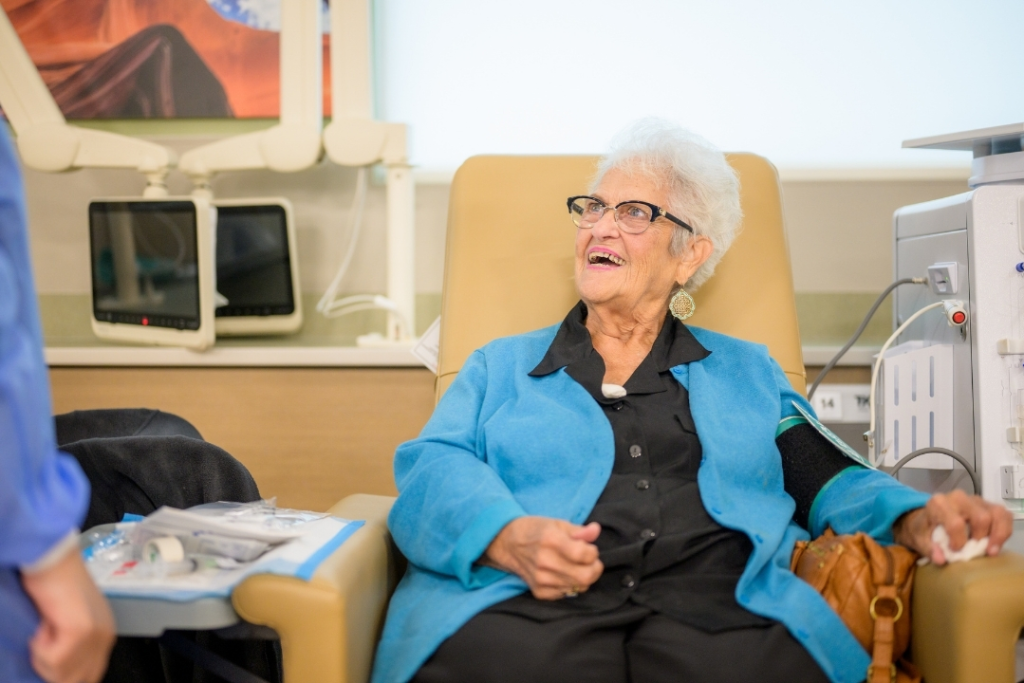 Woman in chair smiling while being treated